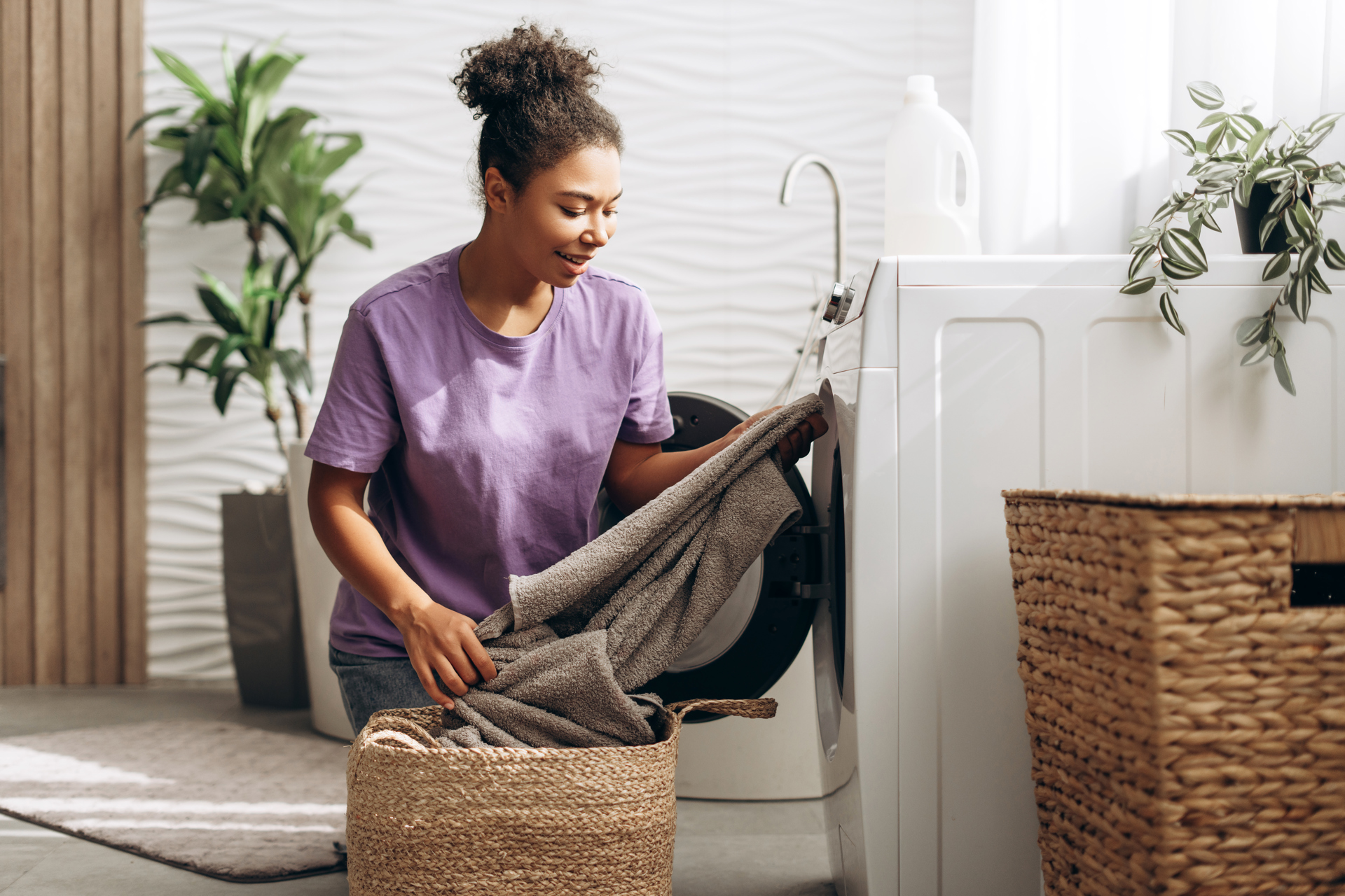 Mevrouw doet de was in de wasmachine zittend op haar hurken